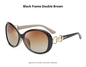 Detail of polarized oversized sunglasses with gold chain link trim and brown gradient lenses