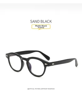 Detailed close-up of matte sand black round eyeglass frame with vintage metal rivets