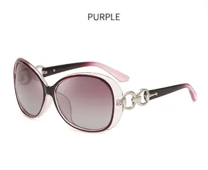 Detail of oversized purple sunglasses showing metal chain hinge with rhinestones