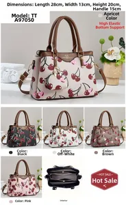 Detail view of cherry print handbag with interior zip compartments and leather texture