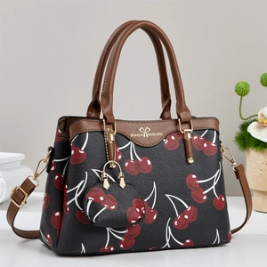 Elegant black tote bag with red cherry prints and brown straps for modern women