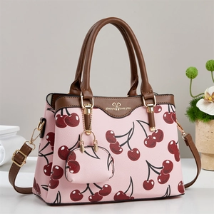 Pink tote bag with cherry print, brown leather handles and a matching small coin purse