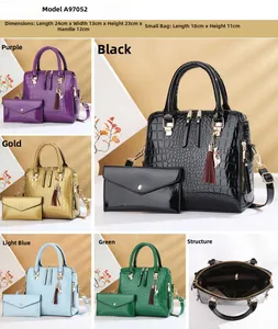 Detail of crocodile pattern tote bag with tassel charm and matching envelope clutch set