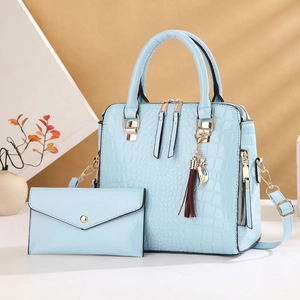 Light blue faux crocodile skin tote bag and matching clutch set with a red tassel charm