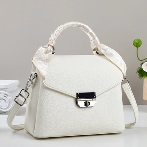 Détail du sac à main en cuir blanc avec poignée en soie et fermoir métallique