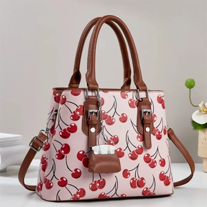 Pink cherry print tote bag with brown leather handles and a matching mini charm