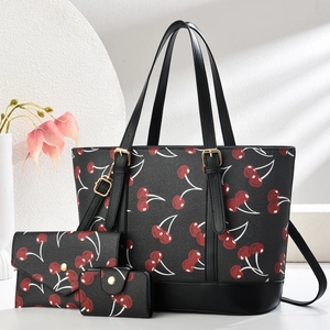 Detailansicht des dreiteiligen Handtaschen-Sets mit Kirschmustern und goldener Hardware