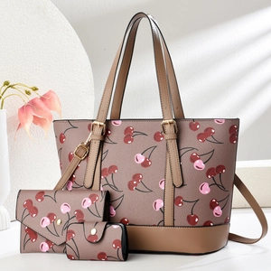 Detailansicht des dreiteiligen Shopper-Sets mit Kirschmuster und goldener Hardware
