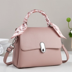 Pink lychee grain leather crossbody bag with scarf-wrapped handle and silver twist lock