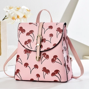 Pink backpack with cherry print, pebbled leather texture, and gold buckle closure