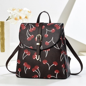 Detail of cherry pattern tote bag with leather handle and gold buckle closure