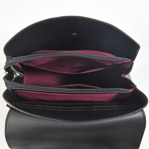 Detail of black tote bag interior with wine red lining and double zipper compartments