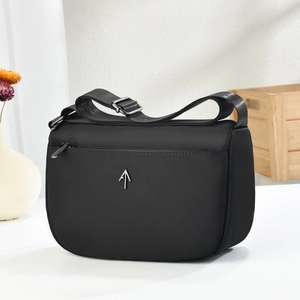 Fashionable black nylon crescent crossbody bag with adjustable strap and metal logo
