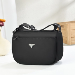 Minimalist black nylon crossbody bag with silver triangle logo and adjustable strap