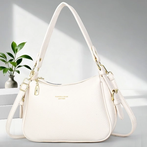 Sac hobo chic en cuir beige avec détails dorés posé sur une marche grise minimaliste