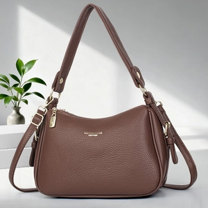 Sac à bandoulière minimaliste en cuir litchi marron avec détails dorés en exposition