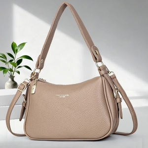 Détail du sac à main en cuir souple grainé avec fermeture éclair dorée et logo