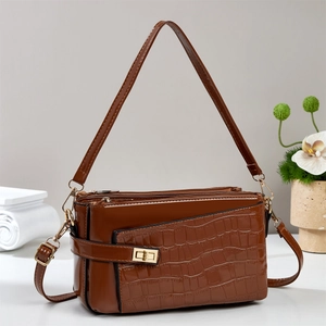 Polished dark brown crocodile pattern handbag with gold hardware and shoulder strap