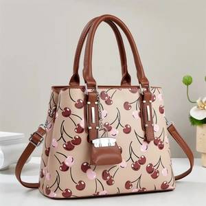 Elegant beige tote bag with vibrant cherry prints and brown handles for daily fashion wear