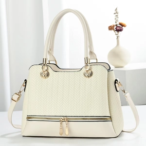 Beige structured tote bag with embossed texture and gold hardware on white background