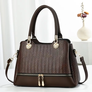 Deep brown crossbody tote with herringbone texture and gold shell hardware detail