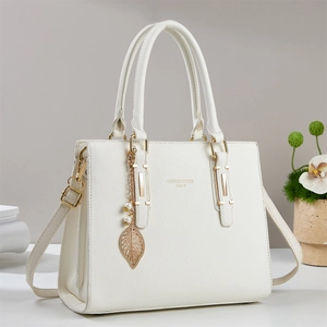 Elegante borsa a mano bianca in pelle con dettagli dorati e ciondolo di perle