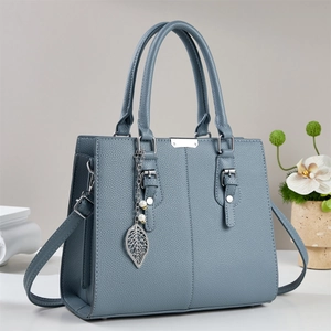 Sac bandoulière en cuir grainé bleu clair avec pendentif perle et finitions argentées
