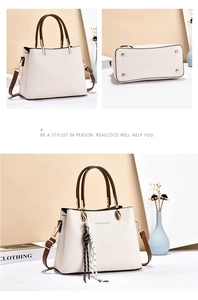 Detail view of beige lychee leather handbag with golden feet and striped silk scarf