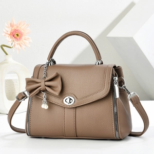 Brown litchi grain leather crossbody bag with pearl bow charm and silver swivel lock