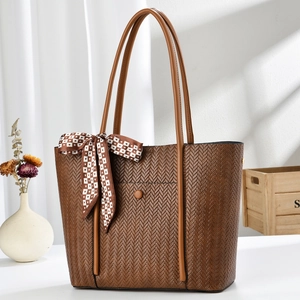 Large brown woven tote bag with shoulder strap and decorative silk scarf for commute