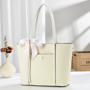 Detail of herringbone woven tote bag with decorative scarf and elegant buckle pocket