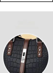 Détail du sac à main gaufré crocodile avec bride contrastée et fermoir rotatif argenté
