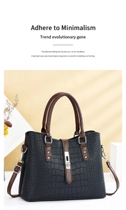 Détail du sac à main en cuir motif crocodile avec fermoir rotatif et poignée marron