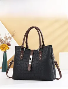 Vue de face d'un sac à main noir texture crocodile avec poignées marron et fermoir argenté