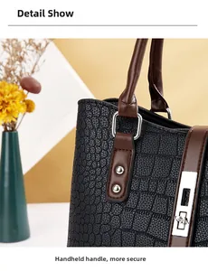 Détail du sac à main motif crocodile avec ferrures argentées et boucle de poignée solide