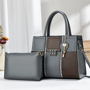 Chic two-piece set featuring a large grey and brown leather tote bag with a gold key charm