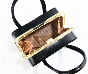 Détail du sac en cuir noir avec cadre en diamant et fermoir à boucle en perles