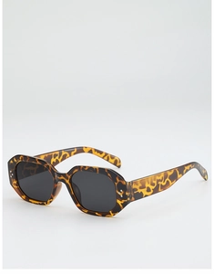 Détail de lunettes de soleil écaille avec verres hexagonaux sombres et accents argentés