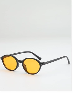 Détail de lunettes de soleil rondes rétro avec monture noire et verres orange vif