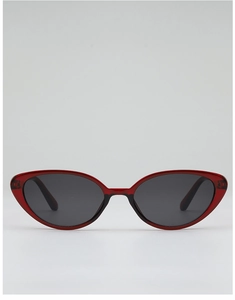 Detailed view of red translucent cat-eye sunglasses with dark protective lenses