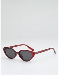 Detail of translucent burgundy cat eye sunglasses with metallic stud accents and grey lenses
