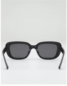 Detail view of square black sunglasses with polished frames and dark gray sun lenses
