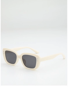 Detail of cream rectangle sunglasses featuring silver rivets and dark grey lenses
