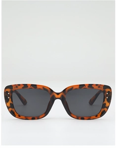 Detail of square oversized tortoiseshell sunglasses with metal rivets and dark lenses