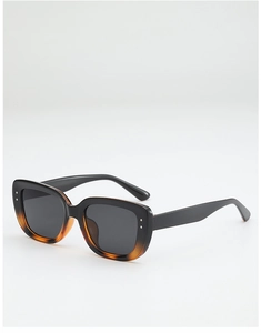 Detail view of square sunglasses featuring silver rivets and tortoiseshell frame texture