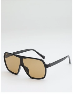 Detail of oversized black frame sunglasses with amber translucent lenses and unibody design
