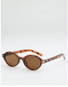 Detail view of tortoiseshell frame sunglasses with dark lenses and silver metal hinges