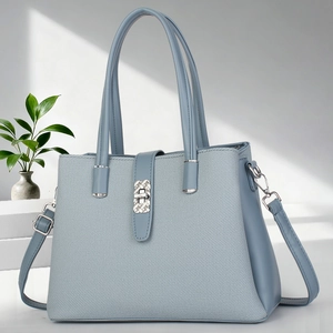 Close-up of light blue leather handbag with twill fabric and silver metallic buckle