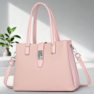 Detailed close-up of a pink luxury tote bag with silver buckle on a minimalist pedestal