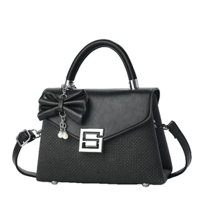 Black textured shoulder bag with leather flap, silver square buckle and pearl bow charm